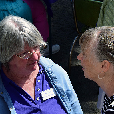 Mary Knepp having a conversation with woman during porch blessing dedication